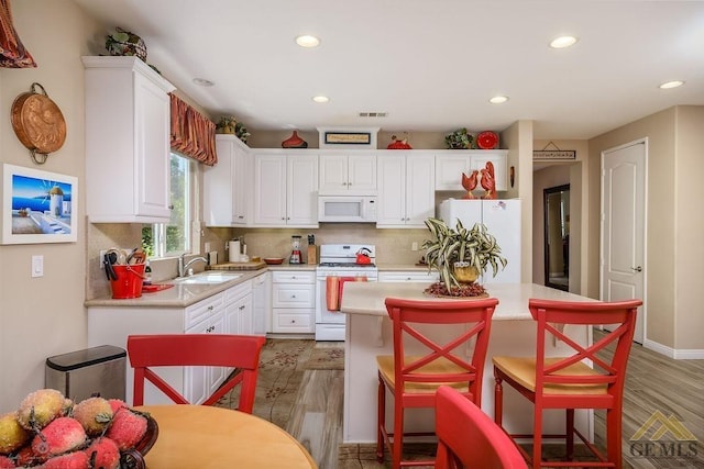 kitchen featuring white cabinets, sink, white appliances, and backsplash