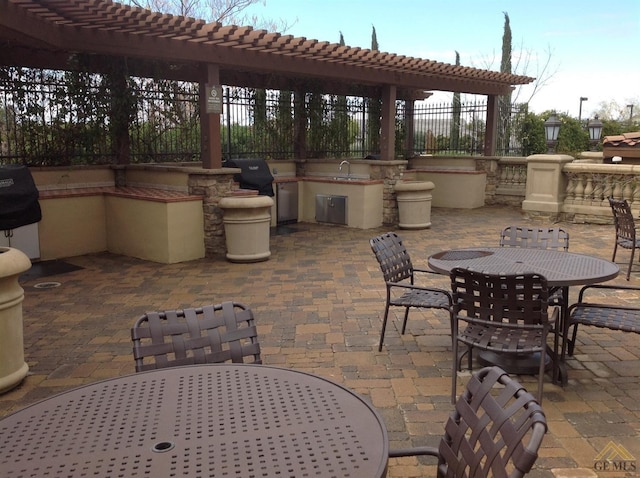 view of patio / terrace featuring a grill, sink, and exterior kitchen