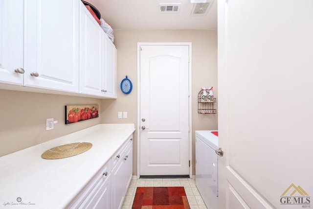 clothes washing area with cabinets and washer / dryer