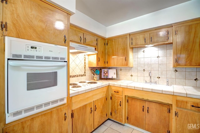 3504 Planz Rd, Bakersfield, CA 93309 - kitchen featuring white appliances, under cabinet range hood, backsplash, and light tile patterned floors