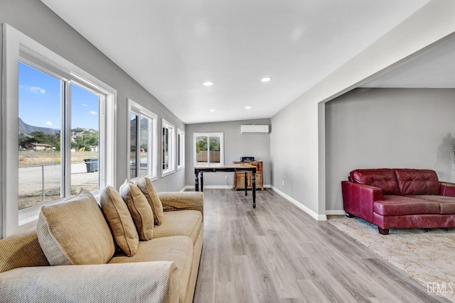 living room featuring lofted ceiling, light wood-type flooring, and a wall mounted AC