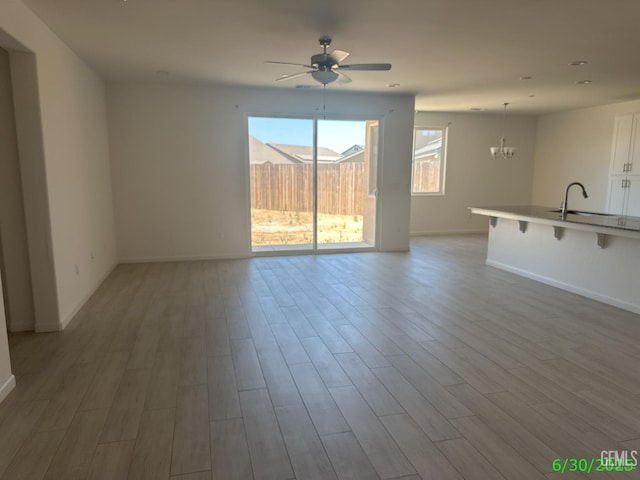 716 Montejo Ct, Delano, CA 93215 - unfurnished living room with ceiling fan, wood finished floors, and a chandelier