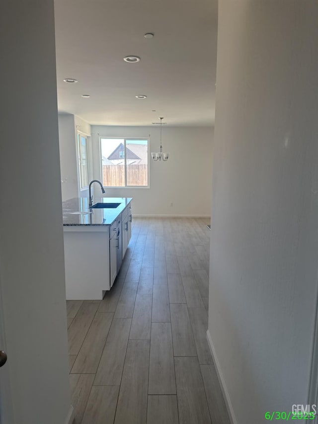 716 Montejo Ct, Delano, CA 93215 - corridor with light wood-type flooring, a chandelier, and recessed lighting