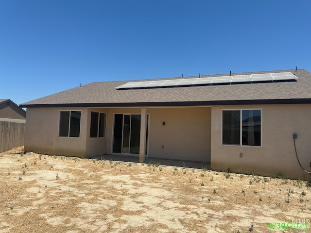 716 Montejo Ct, Delano, CA 93215 - back of property featuring a shingled roof, solar panels, and stucco siding