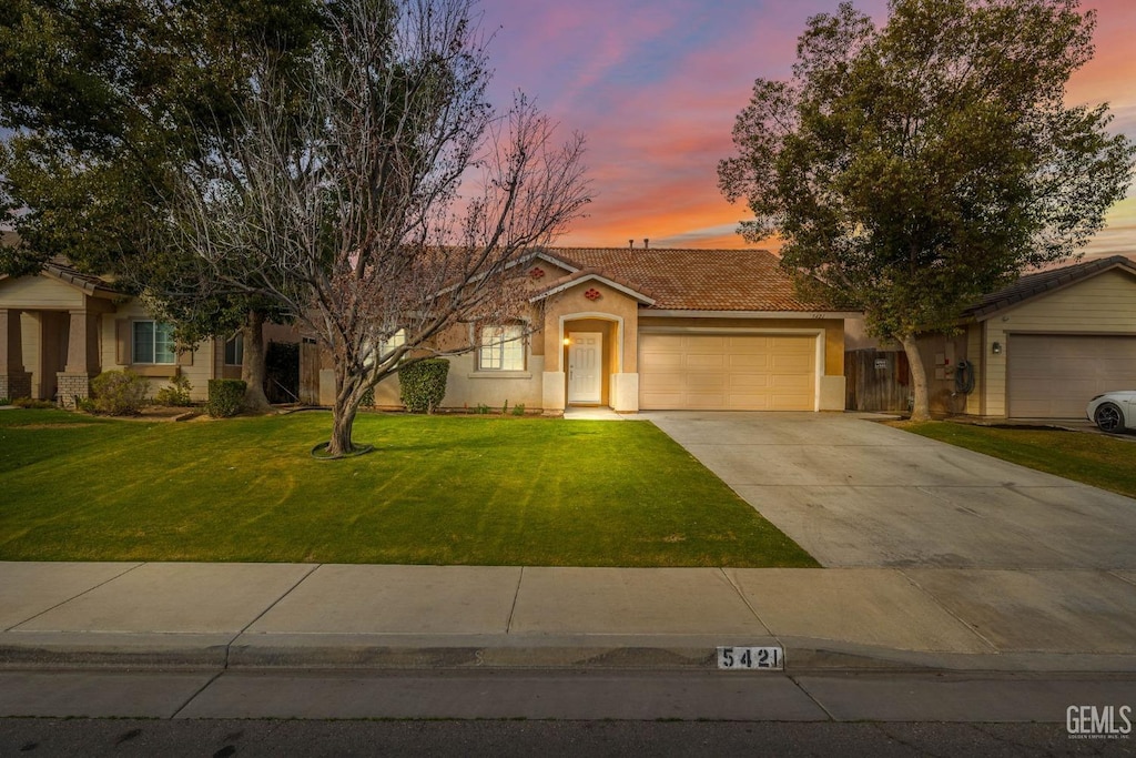 view of front of home featuring a garage and a lawn