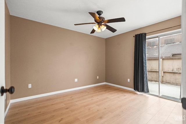 spare room with light wood-type flooring, a ceiling fan, and baseboards