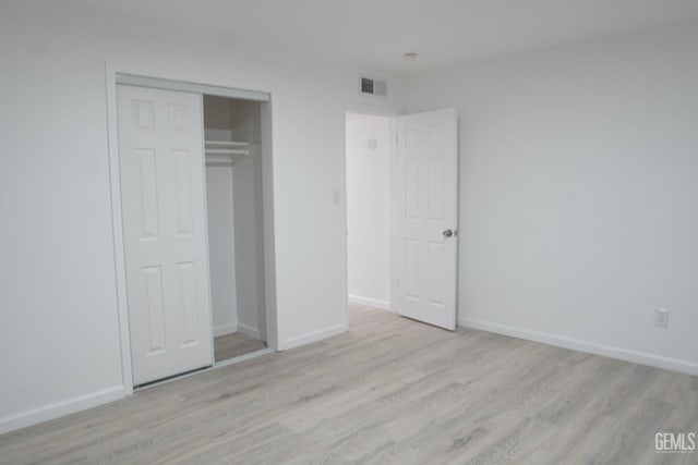 unfurnished bedroom featuring visible vents, light wood-style flooring, and baseboards