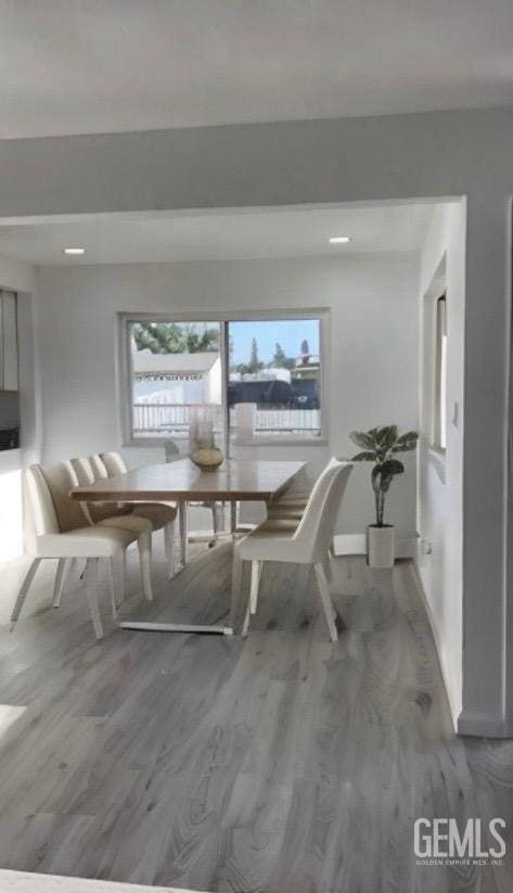 unfurnished dining area with baseboards and wood finished floors