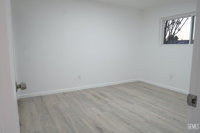 unfurnished room featuring baseboards and wood finished floors