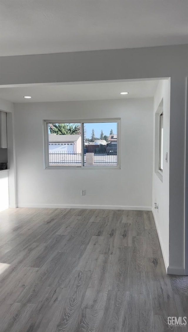 unfurnished room featuring recessed lighting, wood finished floors, and baseboards