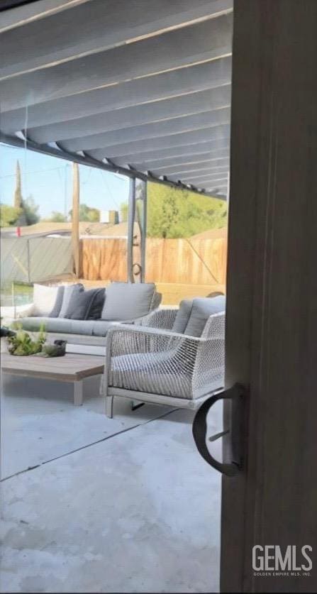 view of patio featuring outdoor lounge area and fence