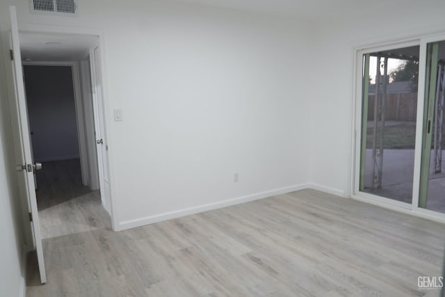 empty room with visible vents, baseboards, and wood finished floors