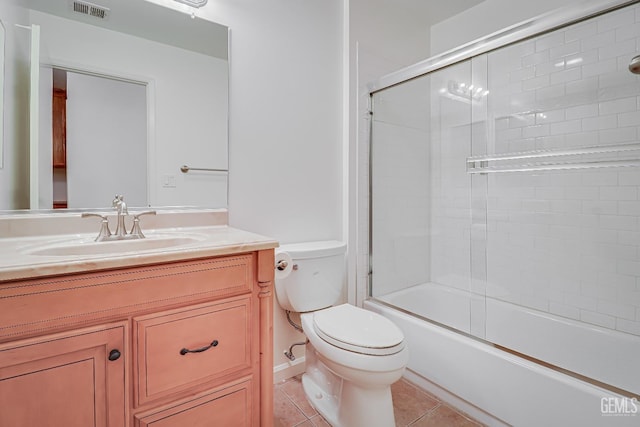 full bathroom featuring tile patterned flooring, toilet, bath / shower combo with glass door, vanity, and visible vents