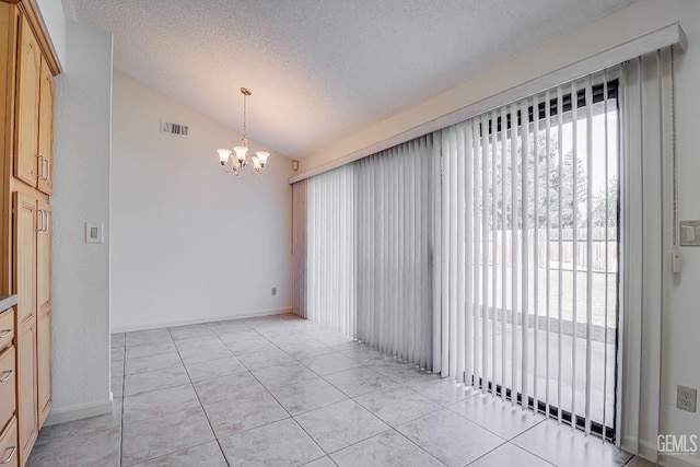 spare room featuring light tile patterned floors, a textured ceiling, a notable chandelier, visible vents, and vaulted ceiling