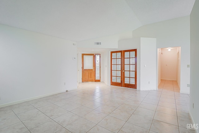 empty room featuring baseboards, visible vents, lofted ceiling, french doors, and light tile patterned flooring