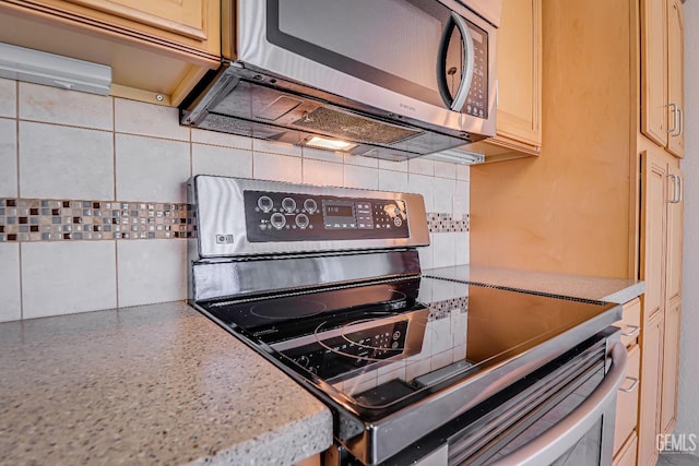 kitchen with light countertops, appliances with stainless steel finishes, and backsplash