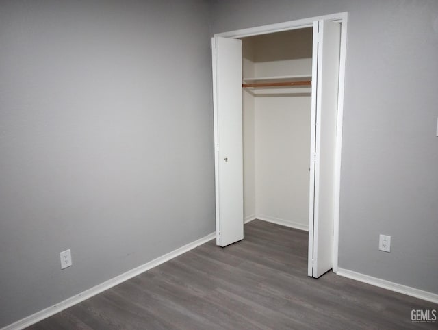 unfurnished bedroom featuring a closet and dark hardwood / wood-style floors