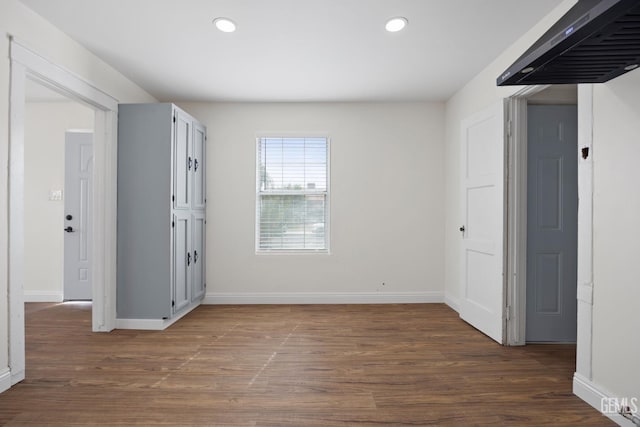 spare room with baseboards, dark wood-type flooring, and recessed lighting