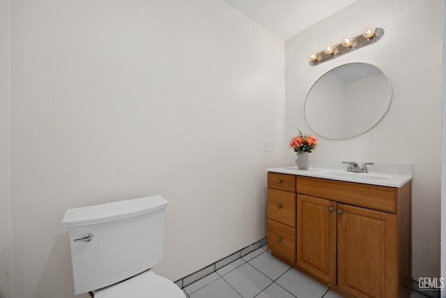 half bathroom with toilet, vanity, and tile patterned floors