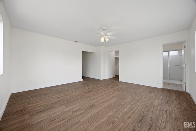 unfurnished room with a ceiling fan, baseboards, and wood finished floors