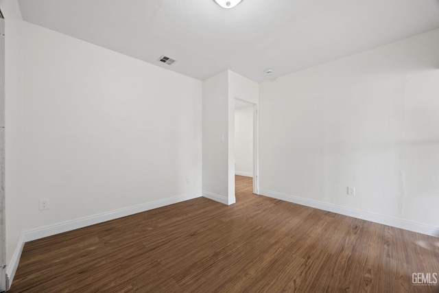 unfurnished room with visible vents, baseboards, and wood finished floors