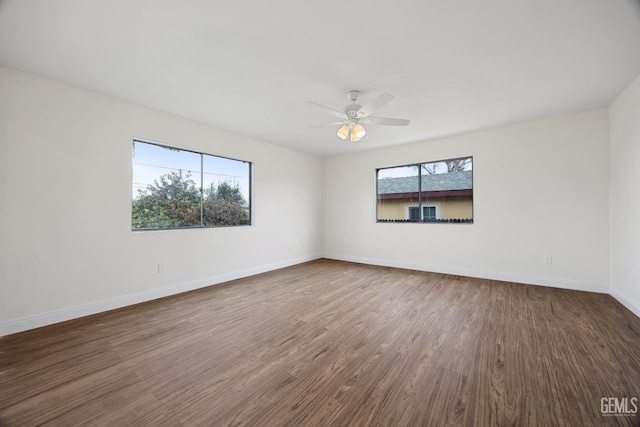 spare room featuring ceiling fan, baseboards, and wood finished floors