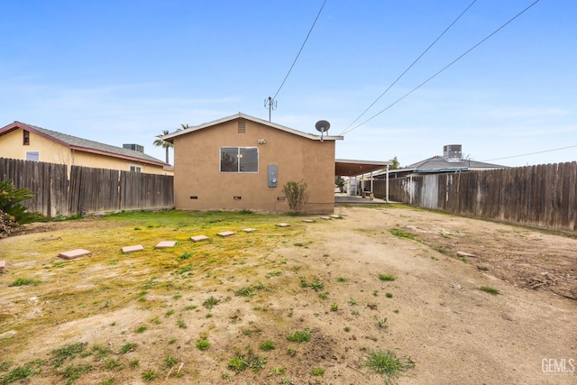 rear view of property featuring crawl space, fence, and stucco siding