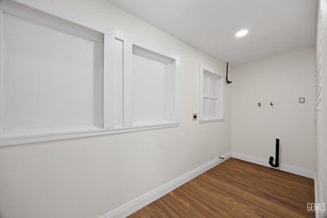 laundry area featuring laundry area, wood finished floors, electric dryer hookup, and baseboards