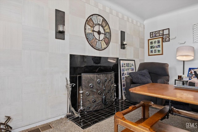 interior space with a tile fireplace and carpet