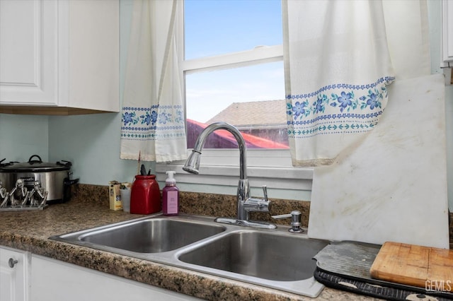 kitchen featuring white cabinetry and sink