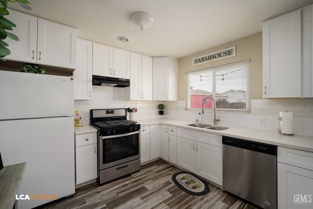 kitchen featuring sink, white cabinets, decorative backsplash, stainless steel appliances, and dark wood-type flooring