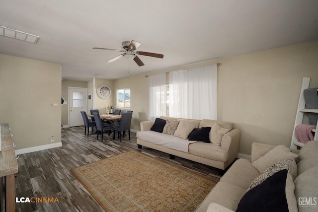 living room featuring dark wood-type flooring and ceiling fan