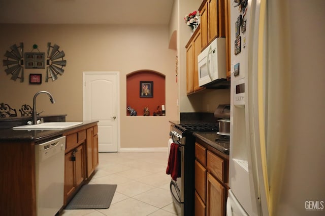 kitchen featuring sink, light tile patterned floors, and white appliances