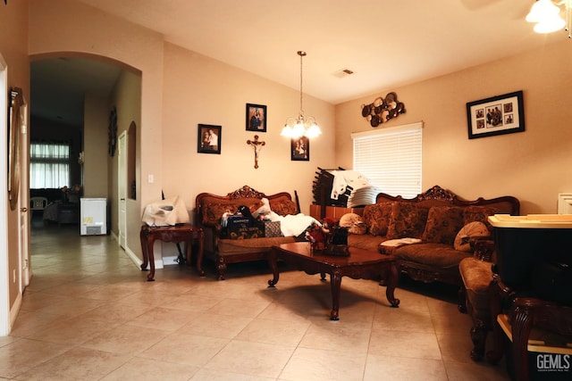 living room featuring lofted ceiling, an inviting chandelier, and light tile patterned flooring