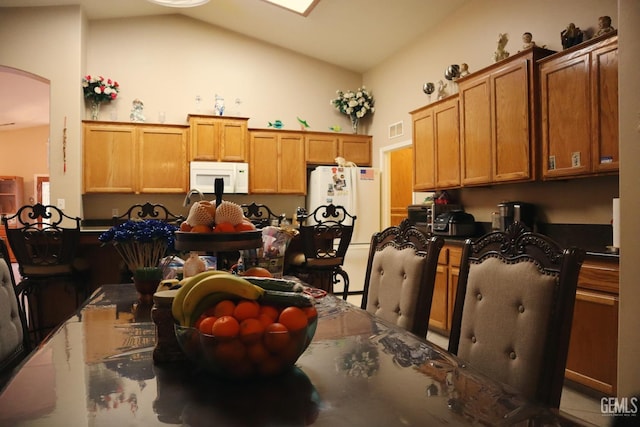 kitchen featuring white appliances and high vaulted ceiling