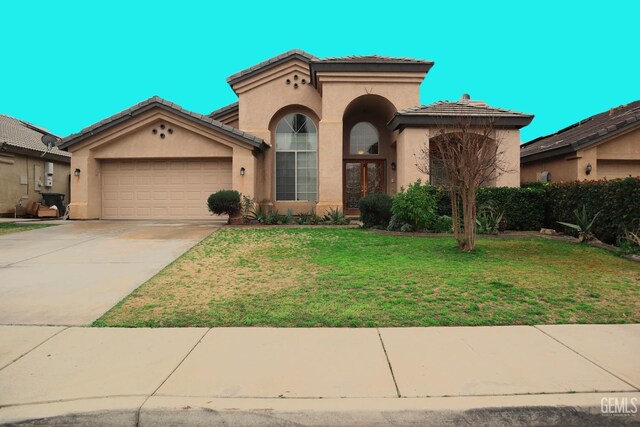 mediterranean / spanish house featuring a front lawn and a garage