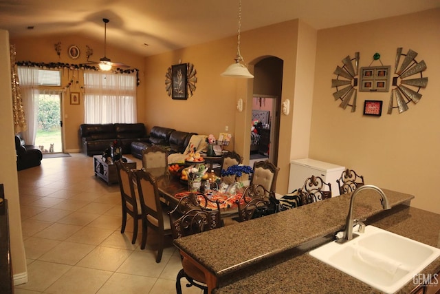 dining space featuring vaulted ceiling, sink, light tile patterned flooring, and ceiling fan