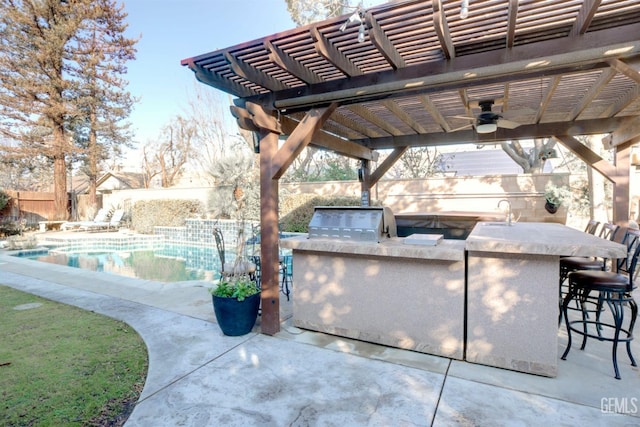 view of patio featuring a bar, an outdoor kitchen, area for grilling, ceiling fan, and a fenced in pool