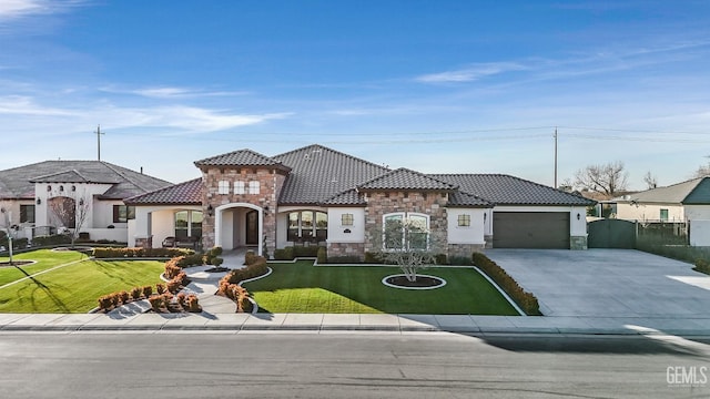 mediterranean / spanish home featuring a garage and a front yard