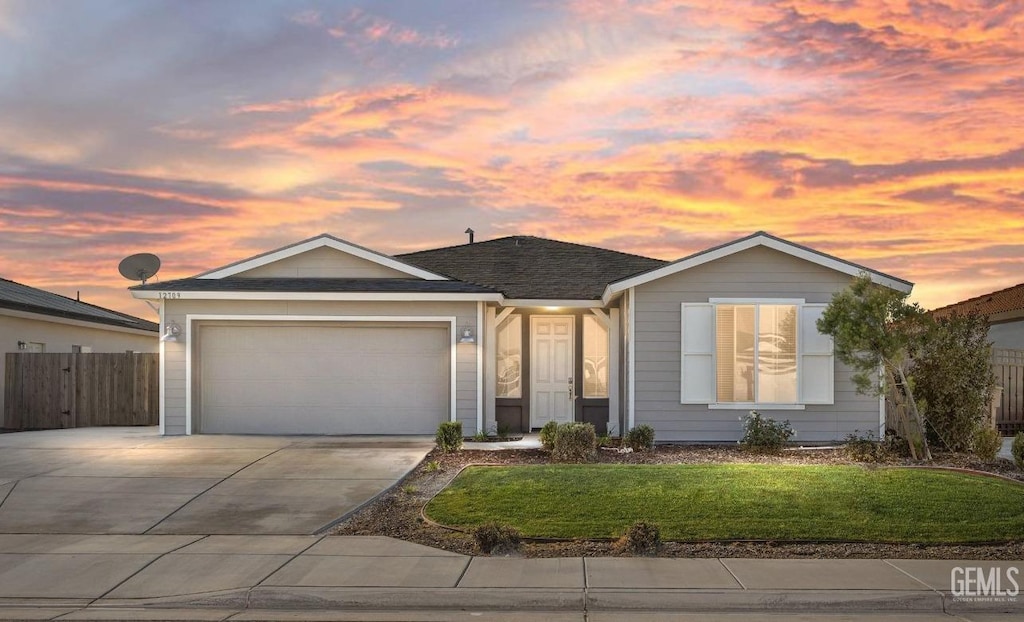 view of front of home with a garage and a lawn