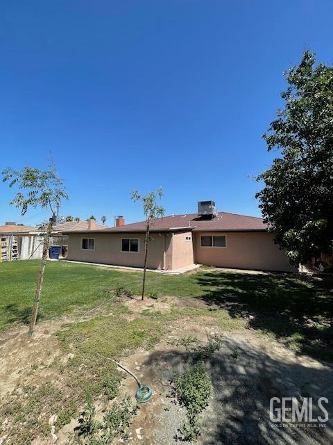 back of house featuring a lawn