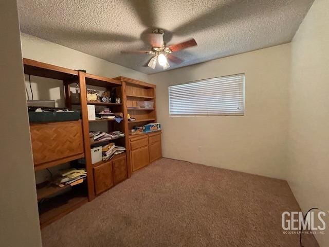 office space featuring ceiling fan, carpet, and a textured ceiling