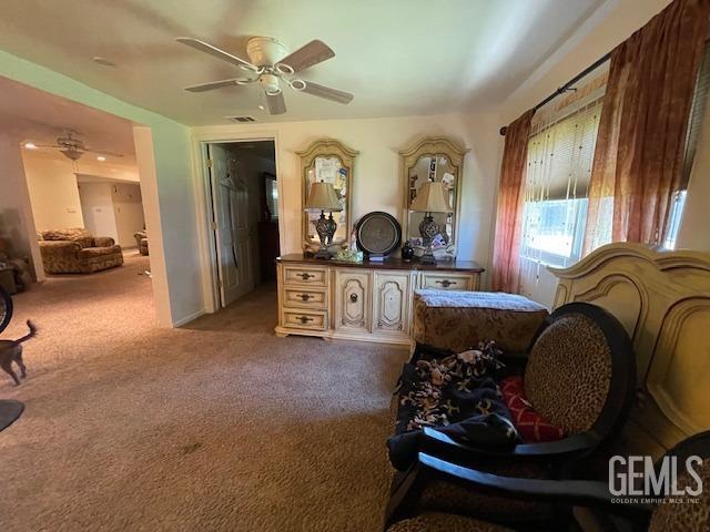 sitting room with ceiling fan and light colored carpet