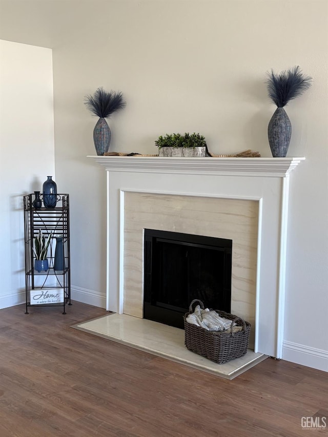 interior details with wood finished floors, a fireplace, and baseboards