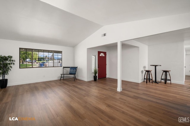 interior space with visible vents, lofted ceiling, baseboards, and wood finished floors