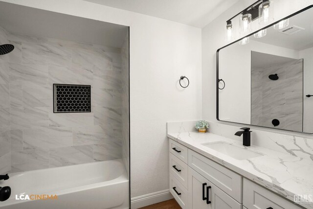 bathroom featuring visible vents, baseboards,  shower combination, and vanity