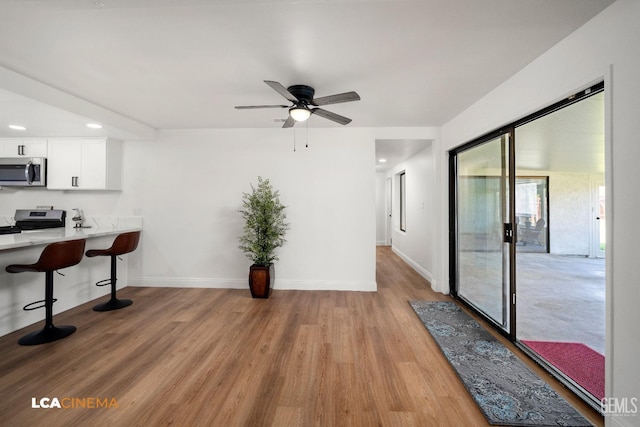 kitchen with light countertops, a breakfast bar area, light wood-style floors, and stainless steel appliances