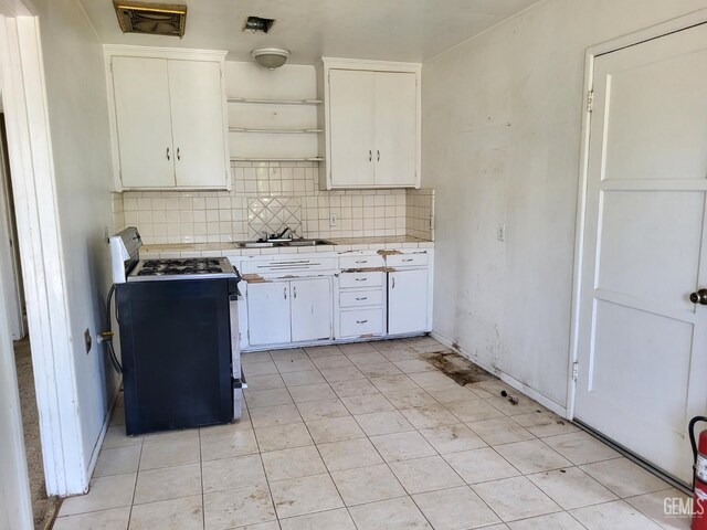 2132 Wingland Dr, Bakersfield, CA 93308 - kitchen with black range with gas cooktop, tile countertops, tasteful backsplash, and white cabinetry