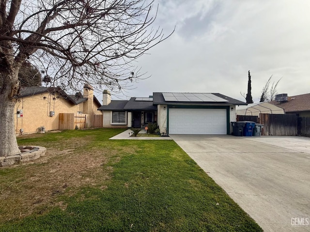 view of front of property with a garage, a front lawn, and solar panels