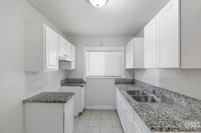 714 R St, Bakersfield, CA 93304 - kitchen with under cabinet range hood, white cabinetry, and light tile patterned floors
